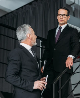 deux hommes en costard en train de discuter dans un escalier