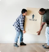 un homme et son fils qui porte un carton