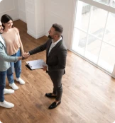un agent immobilier qui sert la main à un couple